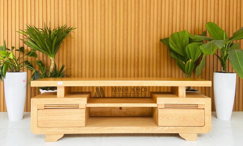 Người phụ nữ đang xem các mẫu kệ tivi phòng khách đẹp trên máy tính bảng để chọn lựa phong cách phù hợp cho không gian nội thất của mình.