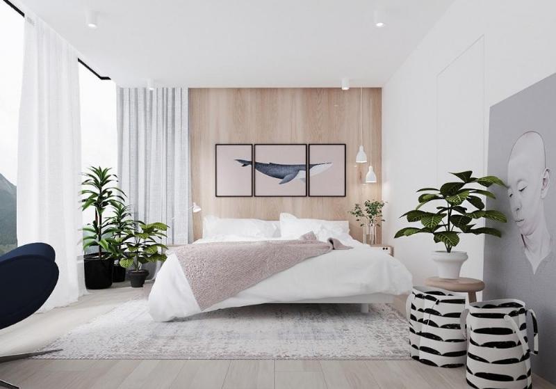 Một người phụ nữ trẻ tươi cười thư giãn bên cửa sổ với cây cảnh, thể hiện lợi ích tinh thần của cây xanh trong nhà.