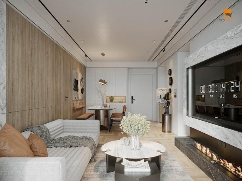 Một góc phòng khách hiện đại với sofa vải màu be, bàn trà gỗ, và một cây xanh lớn. Có một bình hoa tươi trên bàn và đèn chiếu sáng ấm áp, tạo cảm giác sạch sẽ, thoáng đãng và thư thái.