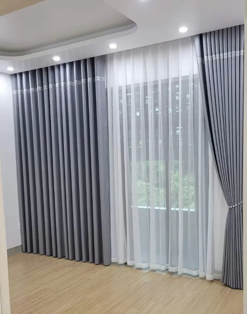 Một phòng ngủ hiện đại với nội thất tối giản, ánh sáng dịu nhẹ, rèm cửa dày và không gian gọn gàng, tạo cảm giác thư thái cho giấc ngủ sâu.