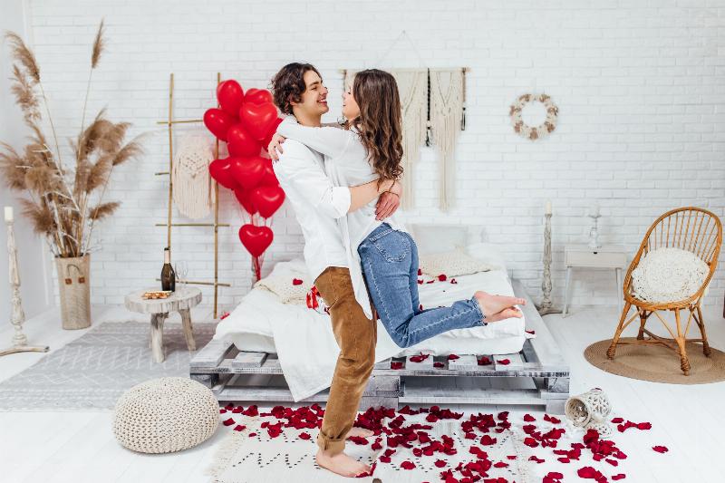 Phòng tân hôn decor đơn giản với nến thơm và hoa tươi, tạo không gian lãng mạn, ấm áp