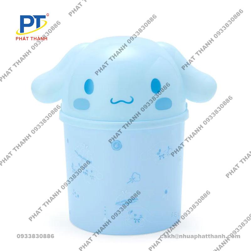Thùng rác mini hiện đại, màu trắng, có nắp đạp chân, đặt trong một phòng tắm sạch sẽ với gạch ốp màu xám và cây xanh
