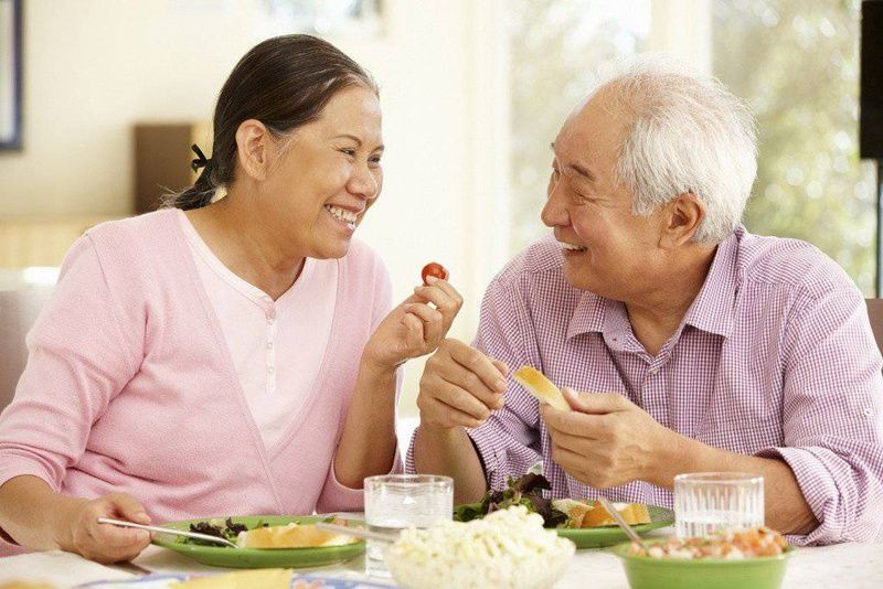 Người cao tuổi đang tập thể dục dưỡng sinh nhẹ nhàng ngoài trời để duy trì sức khỏe và sự dẻo dai.