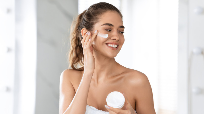 Một người phụ nữ đang vỗ nhẹ lên má sau khi đắp mặt nạ, giúp tinh chất thẩm thấu
