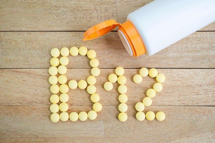 Một người đang uống viên bổ sung vitamin B12, minh họa tầm quan trọng của việc bổ sung hàng ngày để duy trì chức năng tạo máu và thần kinh